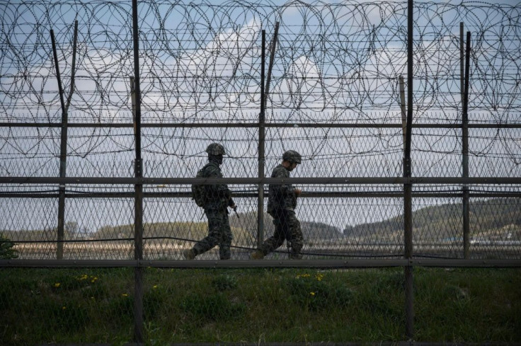 South Korean soldiers patrolling along a barbed wire fence at the Demilitarized Zone with North Korea