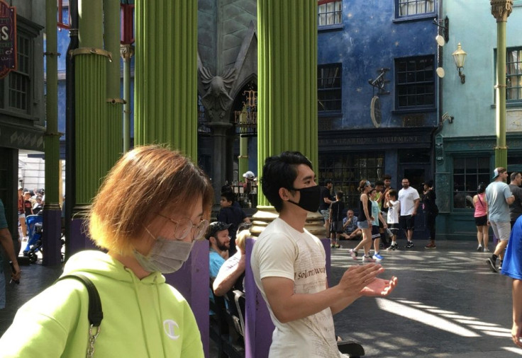 Tourists wear masks as they visit the Wizarding World of Harry Potter at the Universal Studios theme park in Orlando, Florida on March 14, 2020