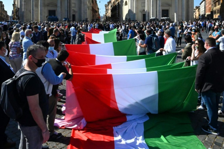 Protesters unfold a giant Italian flag at the start of the demonstration