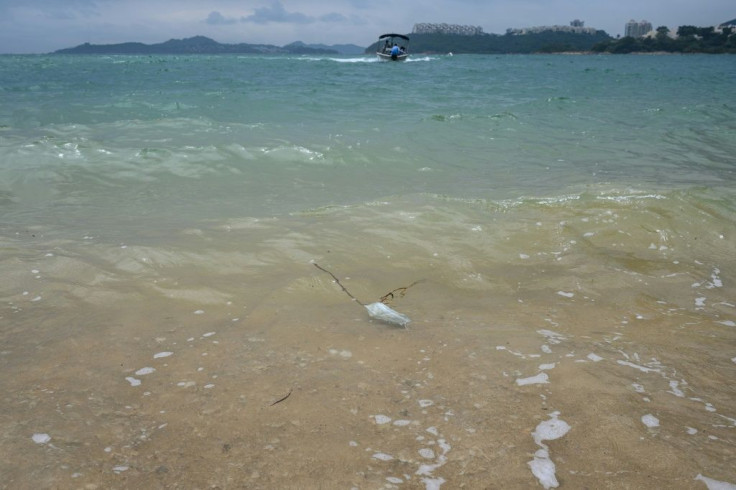 A discarded face mask washes up on a beach in the residential area of Discovery Bay