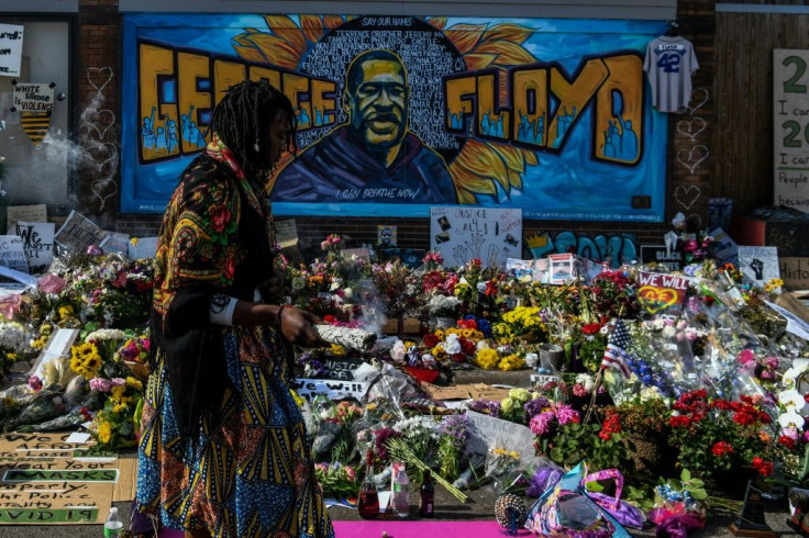 A woman burns sage and offers prayers as she pays her respects at a makeshift memorial in honor of George Floyd, on June 3, 2020 in Minneapolis, Minnesota