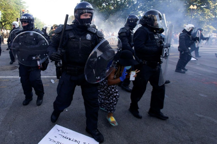 A demonstrator tries to pass riot police as they push back demonstrators outside the White House, June 1, 2020 in Washington DC