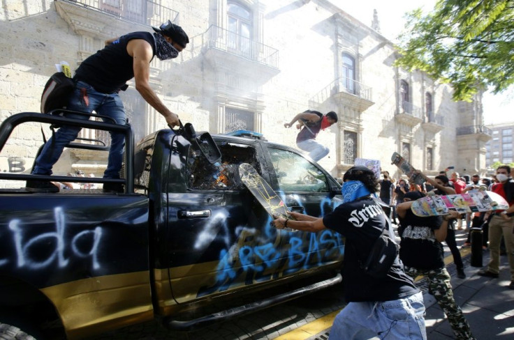 Demonstrators attack a police vehicle during a protest in Guadalajara, Mexico