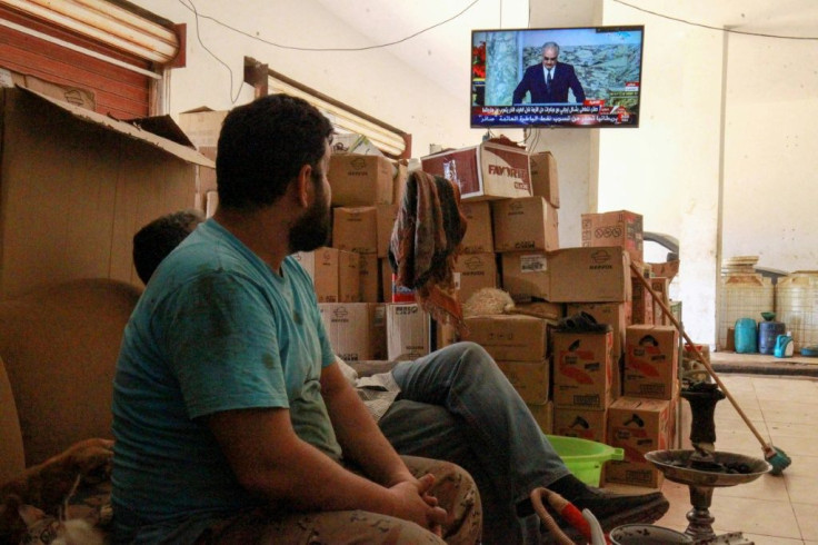 Libyans in the eastern port city of Benghazi watch a televised speech by strongman Khalifa Haftar, whose forces have lost significant ground to a UN recognised government in recent weeks