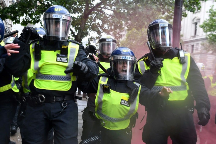 Police officers in riot gear shout to protestors near Downing Street, in central London on June 6, 2020, during a demonstration organised to show solidarity with the Black Lives Matter movement in the wake of the killing of George Floyd