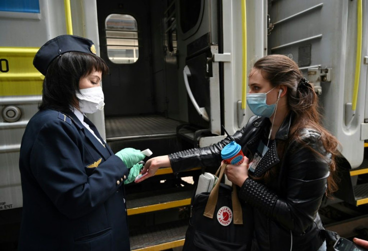A passenger (R) gets a temperature check at the railway station in Kiev, on June 1, 2020 during the coronavirus pandemic