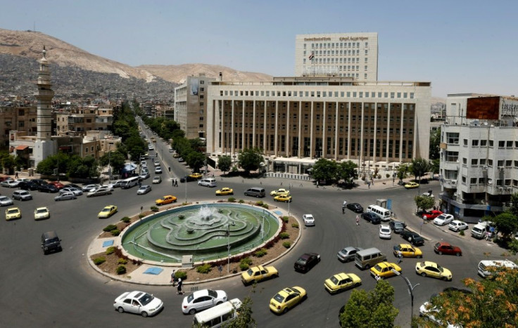Vehicles drive along the roundabout past the Central Bank of Syria in the capital Damascus