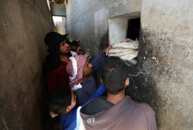 Syrians buy bread at a shop in the town of Binnish in the country's northwestern Idlib province