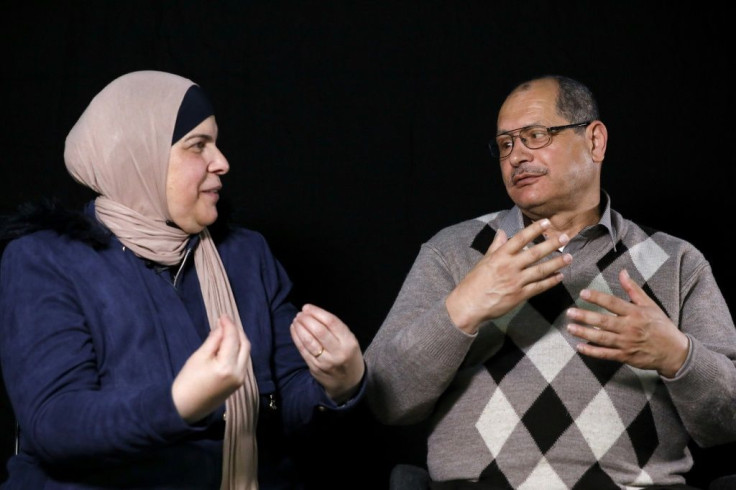 Nafez al-Damiri, a deaf and mute man who lost his right eye, speaks in sign language with his wife during a photo session in Jerusalem