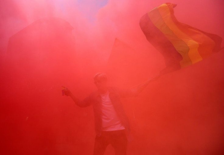 A lone reveller flutters a rainbow flag during a Pride march in Mexico City but most of the celebrations were online