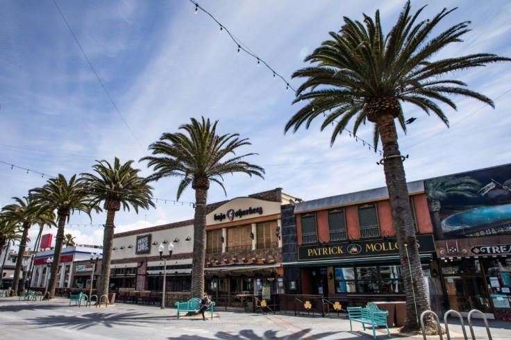 A homeless man sits in front of closed bars and restaurants in Hermosa Beach, California, during the pandemic on March 21, 2020