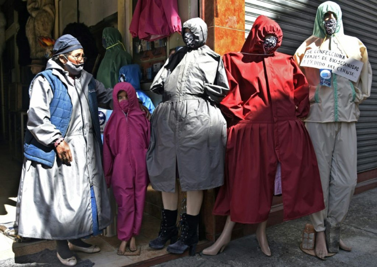 A woman stands next to protective suits designed for âcholitasâ (indigenous women who wear typical skirts) outside a store in La Paz, Bolivia
