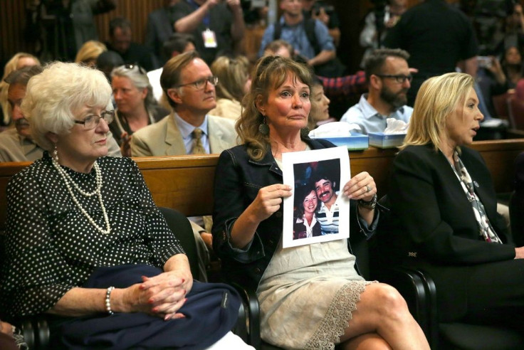 An attendee holds a photo of Cheri Domingo and her boyfriend Gregory Sanchez, killed in 1981, during the arraignment of Joseph James DeAngelo, the suspected "Golden State Killer" on April 27, 2018 in Sacramento