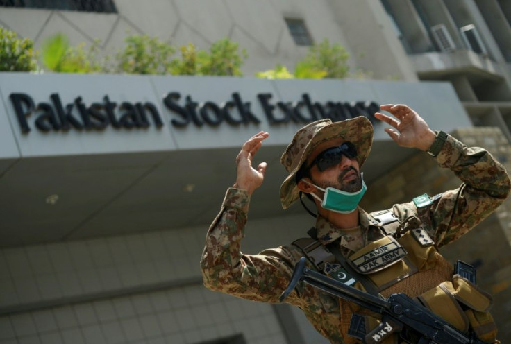 A paramilitary soldier gestures while standing guard outside the Pakistan Stock Exchange  after gunmen attacked the building