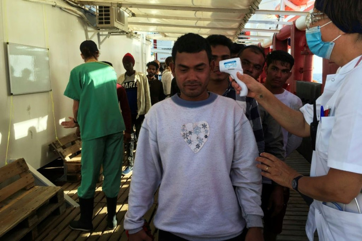 A medic of SOS Mediterranee takes the temperature of rescued migrants