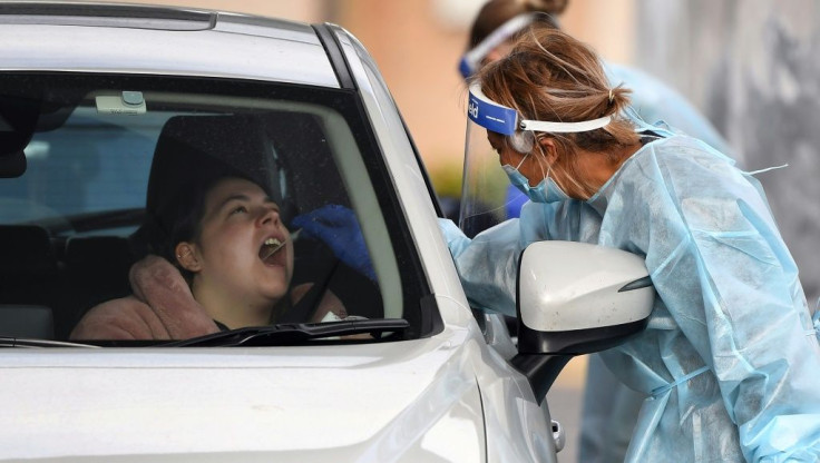 A coronavirus tester takes a swab sample at a drive-through testing station in Melbourne