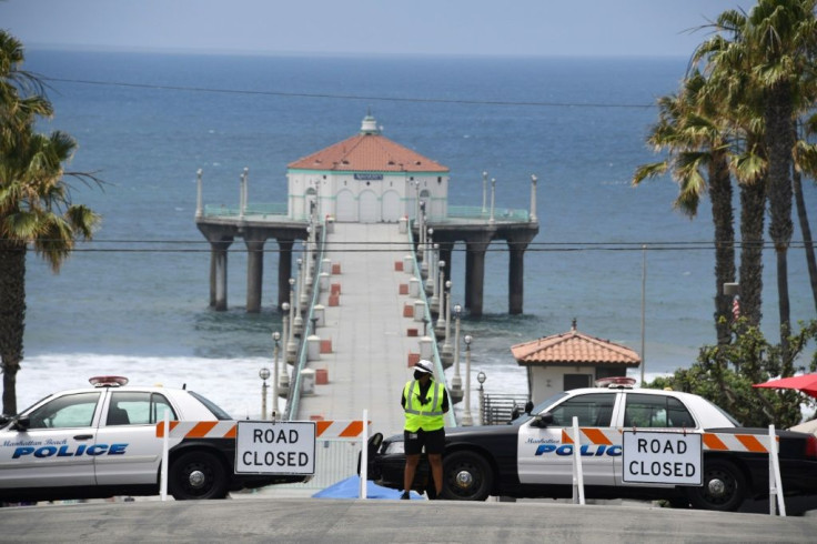 Police block the entrance to the pier in Manhattan Beach, California, where beaches are closed due to a spike in COVID-19 cases