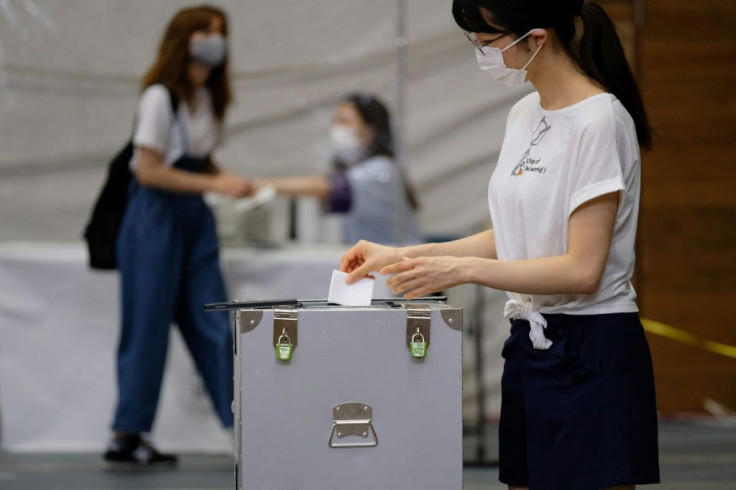 Voters in Tokyo are urged to use hand sanitiser after casting their ballot