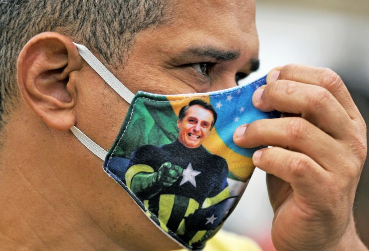 Brazilian president Jair Bolsonaro, whose image can be seen on this person's face mask, has further diluted a law mandating such masks in his country as it struggles with the coronavirus pandemic