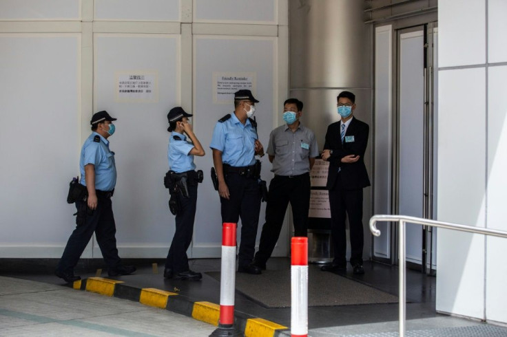 Police speak to staff  at the front door of the Metro Park hotel in Causeway Bay