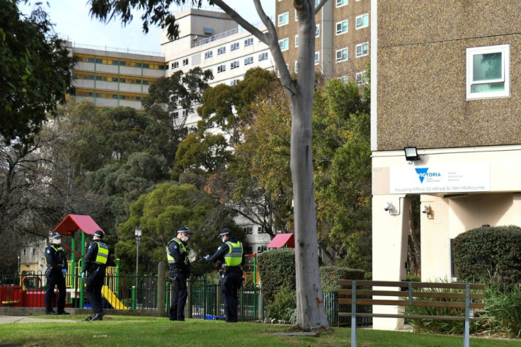 Police stand guard outside a public housing estate locked down in Melbourne due to a spike in coronavirus cases