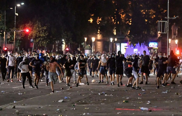 Protesters clash with police near the National Assembly building in Belgrade, on July 10, 2020, during a demonstration against a weekend curfew announced to combat a resurgence of coronavirus infections
