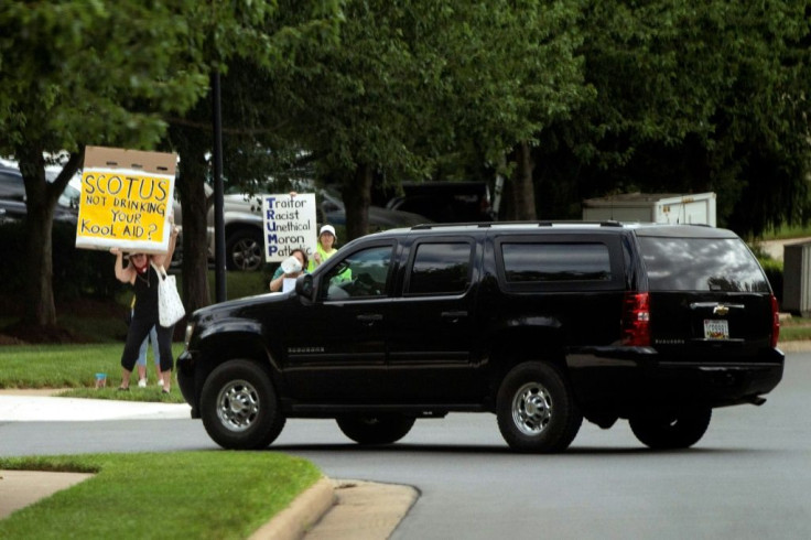 Anti-Trump protesters held up signs as the motorcade carrying President Donald Trump took him to the Trump National Golf Club in Sterling, Virginia on July 11, 2020