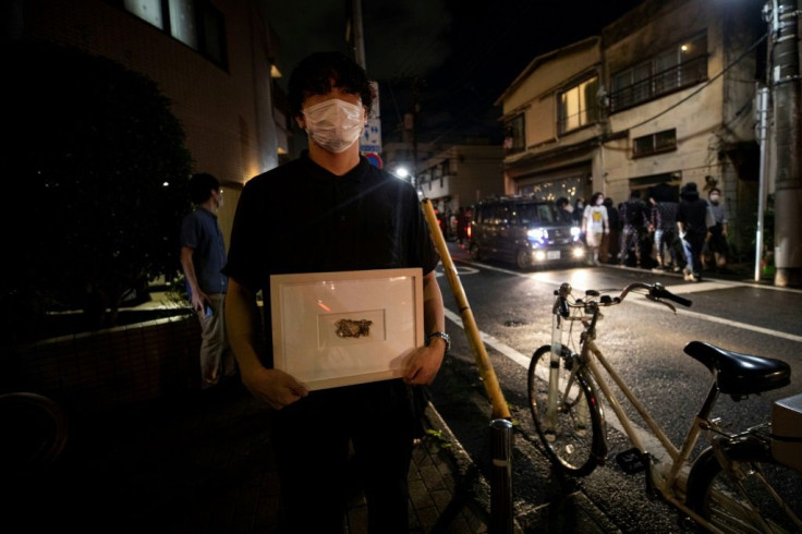 Yusuke Hasada poses with artwork "My Money" created by Gabin Ito outside Same gallery