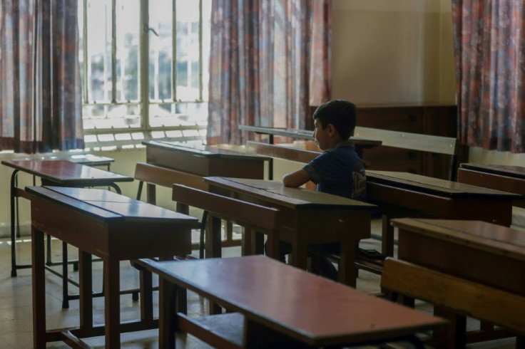 A Lebanese pupil looks out of the window of his empty classroom at Our Lady of Lourdes school, a century-old establishment in the city of Zahle that is due to close because of Lebanon's worst economic crisis sine the 1975-1990 civil war
