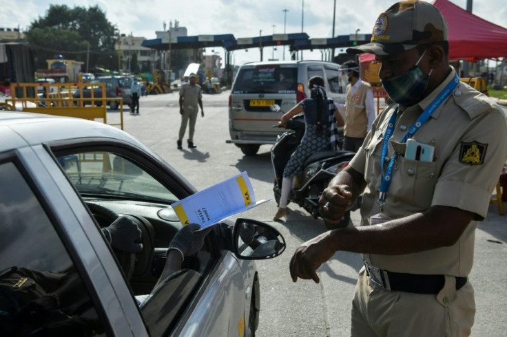 Police stop people travelling to Bangalore and direct them to undergo coronavirus screening as the Indian IT hub imposes a fresh lockdown in an attempt to contain a surge of infections