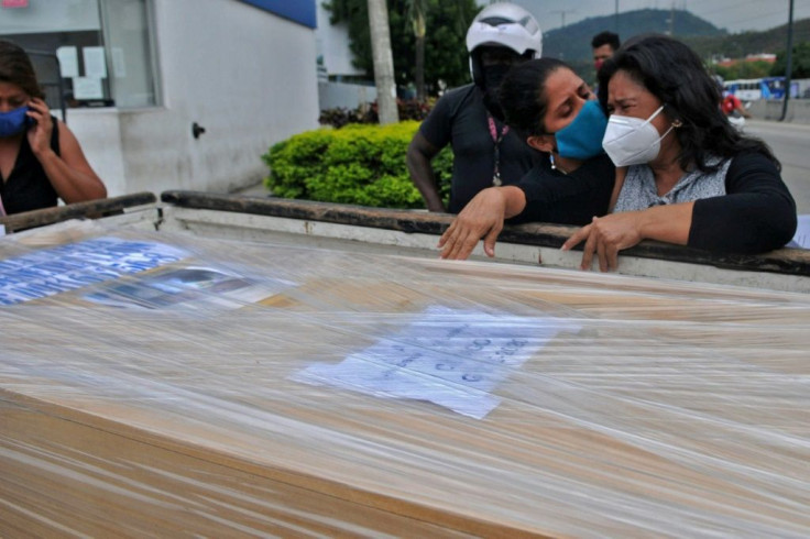 Relatives of Ecuadoran Gardenia Rivadeneira, who died from COVID-19 at the beginning of the pandemic, mourn after receiving her freshly identified remains in Guayaquil, Ecuador, on July 16, 2020