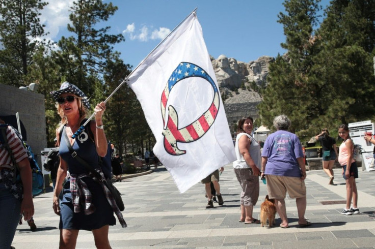 A Donald Trump supporter holding a QAnon flag at Mount Rushmore National Monument in South Dakota
