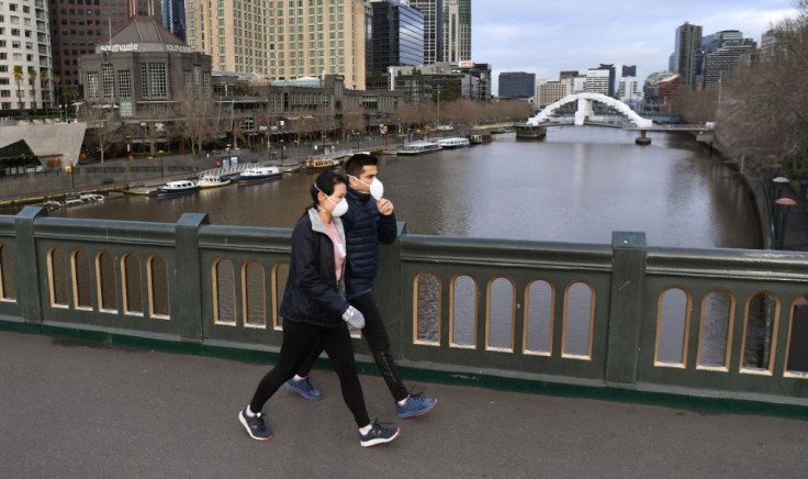 People wear masks as they cross Melbourne's Yarra River