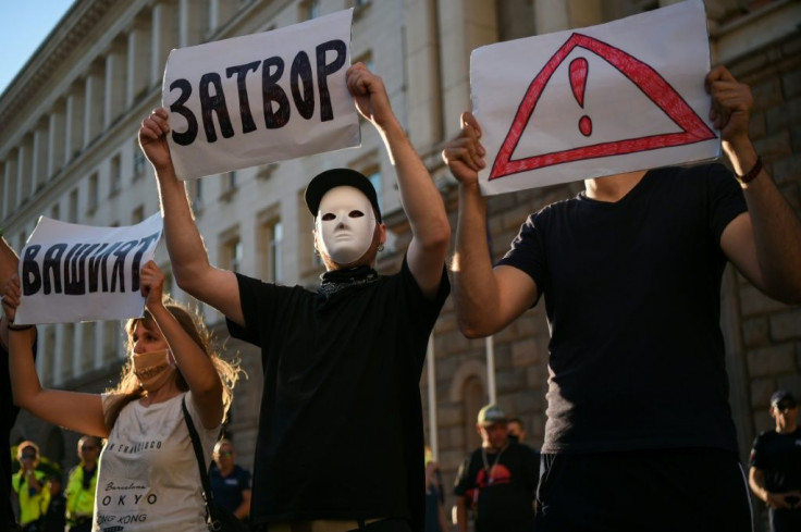 A masked protester holds up a sign reading "Prison" during the anti-government protests in Sofia on Friday