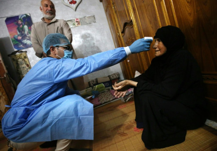 An Iraqi public hospital doctor checks a woman's temperature for COVID-19 in the capital Baghdad's suburb of Sadr City earlier this year