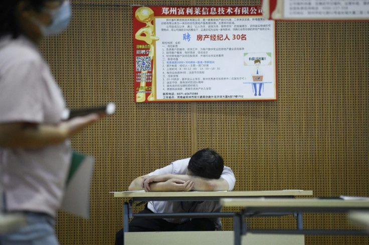A jobseeker takes a break at a recruitment fair in Zhengzhou, China. Young graduates face a tough employment market