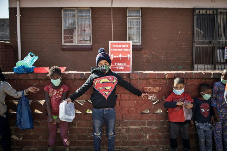 Children try to respect social distancing as they queue for food at the grassroots charity Hunger has no Religion in Johannesburg