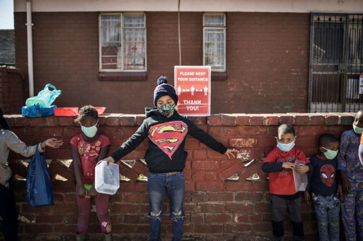 Children try to respect social distancing as they queue for food at the grassroots charity Hunger has no Religion in Johannesburg