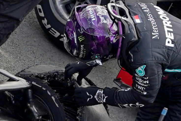 Burning rubber: Lewis Hamilton inspects his punctured tyre after he won the British Grand Prix last weekend