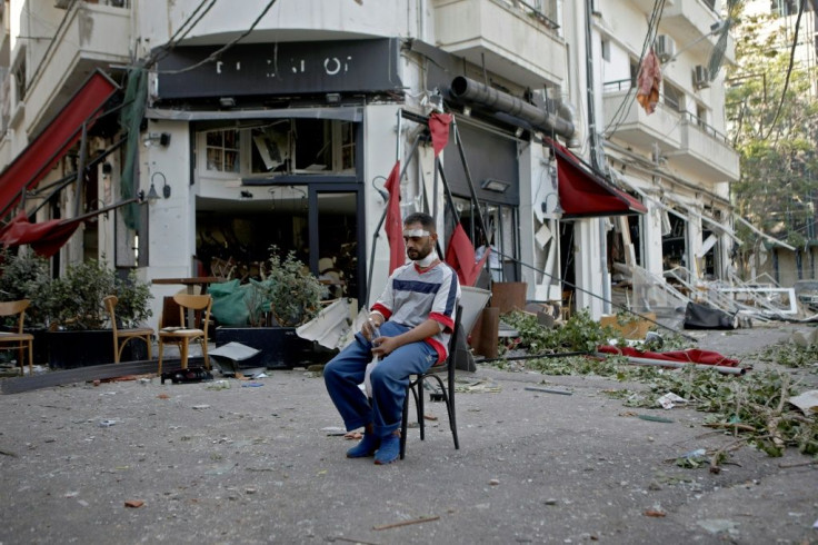 An injured man sits next to a restaurant in the trendy partially destroyed Beirut neighbourhood of Mar Mikhael