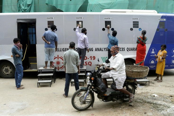 Residents register their names for a free COVID-19 coronavirus test at a mobile testing bus in Hyderabad
