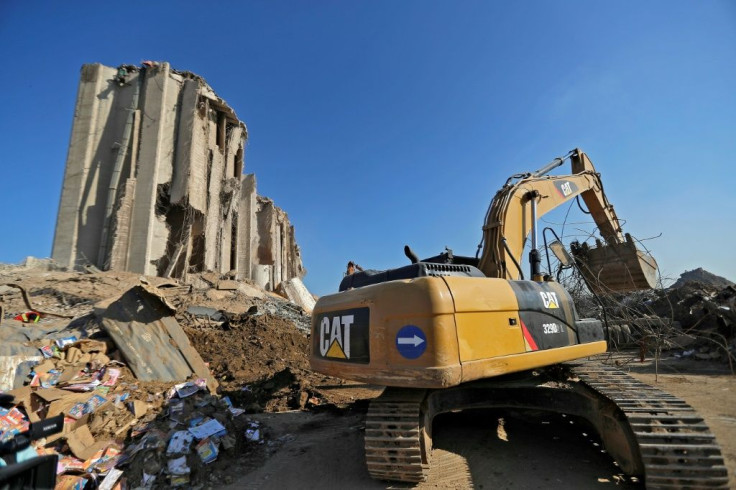 An excavator digs through the mountains of rubble on the Beirut dockside to clear a path for rescuers