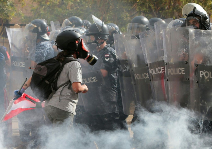 A Lebanese protester faces security forces in downtown Beirut