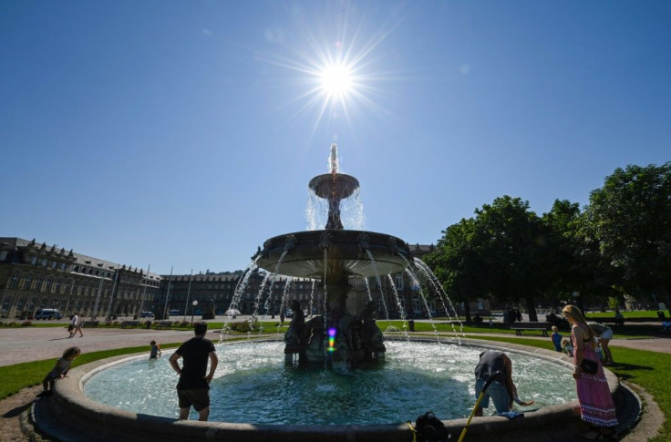 People refresh in a fountain at the Castle Square in Stuttgart, southern Germany, amid a heatwave across Europe