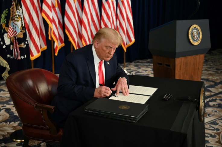 President Donald Trump signs executive actions extending coronavirus economic relief during a news conference at his golf club in Bedminster, New Jersey, on August 8, 2020