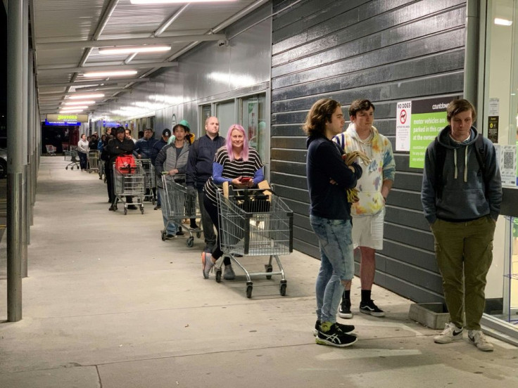 Shoppers wait to enter a supermarket in the suburb of Johnsonville in Wellington