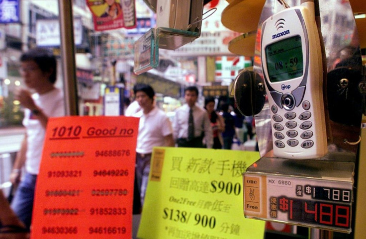 People walk past a mobile phone shop displaying lucky telephone numbers for sale in Hong Kong. Many Asian cultures consider certain numbers -- such as eight -- as good fortune
