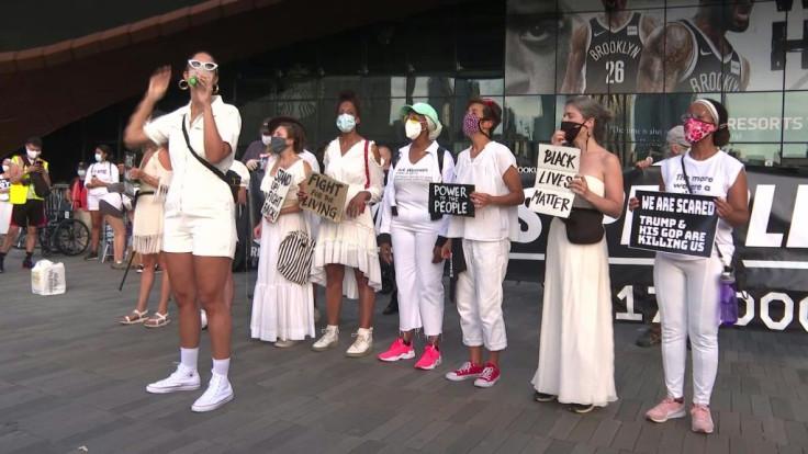 About a hundred protesters dressed in white gather in front of the Barclays Center in Brooklyn, New York, to denounce Donald Trump's response to the COVID-19 pandemic. The outbreak has left 175,000 people dead in the United States. "Itâs a tragedy, I th