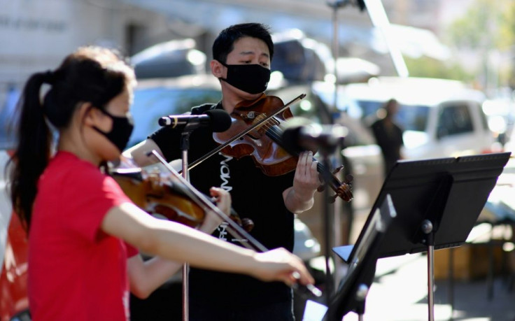 Violinist Quan Ge (L) and violist Cong Wu of the New York Philharmonic are playing street shows as part of the symphony's pandemic-era city tour