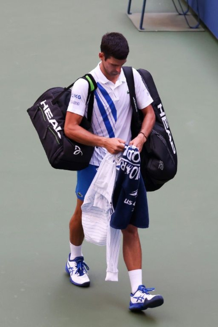 Novak Djokovic of Serbia walks off the court after being defaulted due to inadvertently striking a lineswoman with a ball hit in frustration during his Men's Singles fourth round match against Pablo Carreno Busta of Spain at the US Open